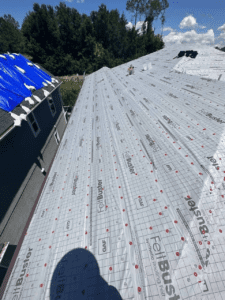 Roofing crew installing shingles on a hip roof