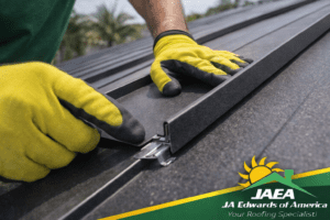 Close-up of standing seam steel roofing panels being aligned and clipped into place during installation.